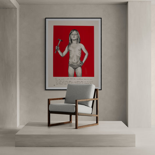 Minimalist room with a design chair and an art print of a child holding a hammer on a strong red background
