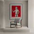 Minimalist room with a design chair and an art print of a child holding a hammer on a strong red background