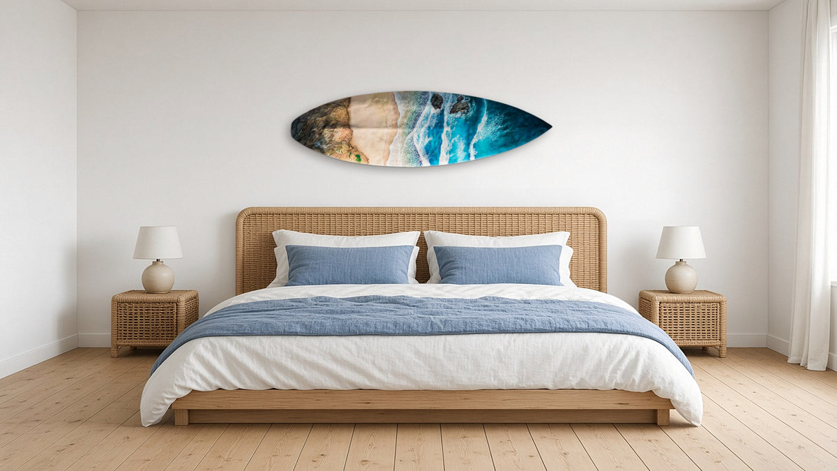 Coast Surfboard by Angie Hickson shown above a rattan headboard in a coastal bedroom