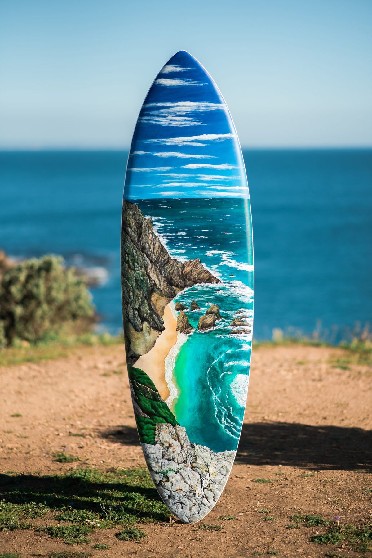 Ursa Surfboard by Angie Hickson – hand-painted surfboard with a cove and cliffs